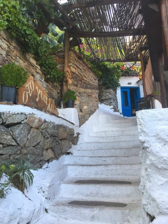 tiny white stairway leading to a blue door at Ikaria, Greece