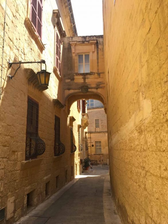 narrow street with sun-baked walls in Mdina, Malta