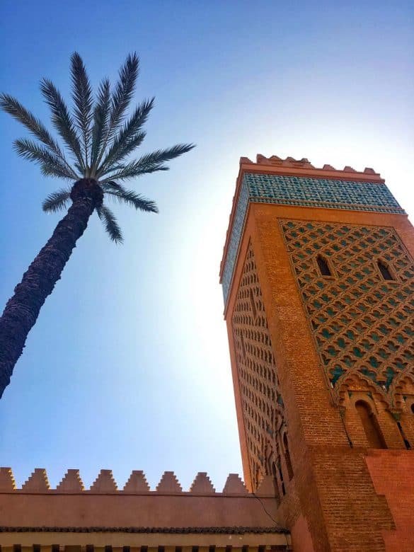 photo of koutoubia mosque tower with a palm tree