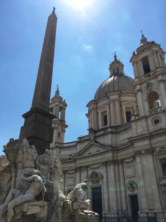 a fountain in rome with statues and roman cathedral