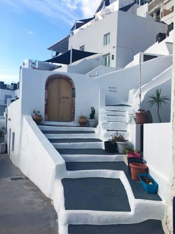 Oia – Greece a light brown door on a white street at santorini