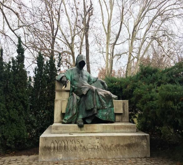 the statue of a mysterious man sitting on bench with his face covered