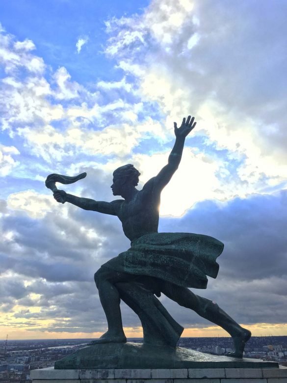 a statue of a man holding a torch depicting liberty at gellert hill budapest