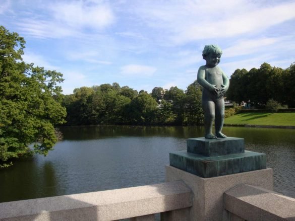 a statue of a boy holding his belly at vigeland park at oslo