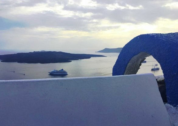 Caldera and sea view through a blue and white chapel at Santorini, Greece