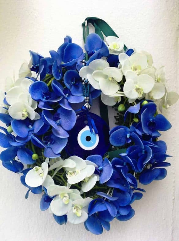 Evil eye inside blue and white flowers at Santorini, Greece