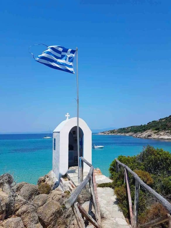 small white church in front of the blue sea at klimataria beach